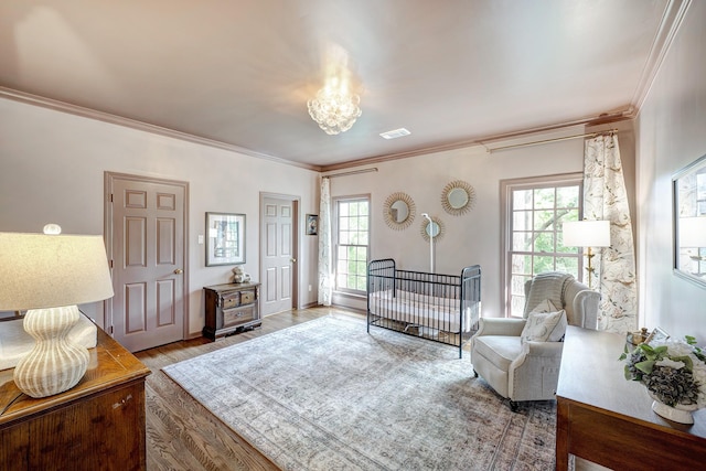 living area featuring ornamental molding, plenty of natural light, wood finished floors, and a chandelier