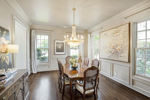 dining area with a decorative wall, a chandelier, healthy amount of natural light, dark wood finished floors, and wainscoting