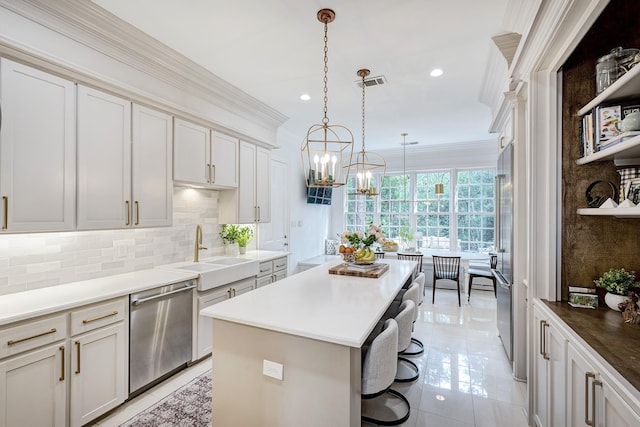 kitchen featuring a sink, dishwasher, a kitchen island, decorative backsplash, and a kitchen breakfast bar