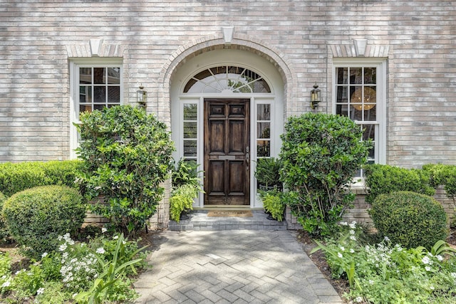 view of exterior entry featuring brick siding