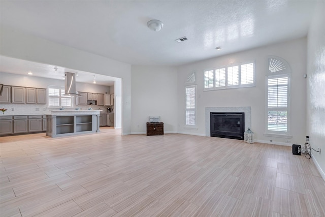 14406 Concord Grv, Houston, TX 77084 - unfurnished living room with baseboards, a glass covered fireplace, and light wood-style flooring