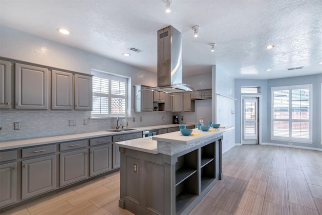 14406 Concord Grv, Houston, TX 77084 - kitchen with gray cabinetry, a sink, island range hood, decorative backsplash, and open shelves