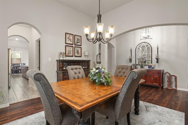 5734 Arden Way, Pasadena, TX 77505 - dining room with arched walkways, a chandelier, wood finished floors, and baseboards