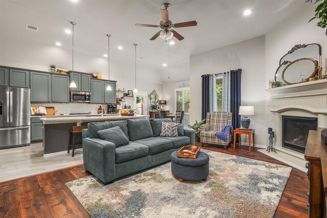 5734 Arden Way, Pasadena, TX 77505 - living area featuring ceiling fan, high vaulted ceiling, wood finished floors, a glass covered fireplace, and recessed lighting