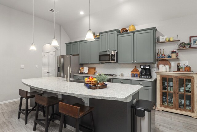 5734 Arden Way, Pasadena, TX 77505 - kitchen with appliances with stainless steel finishes, a sink, light countertops, tasteful backsplash, and a kitchen island with sink