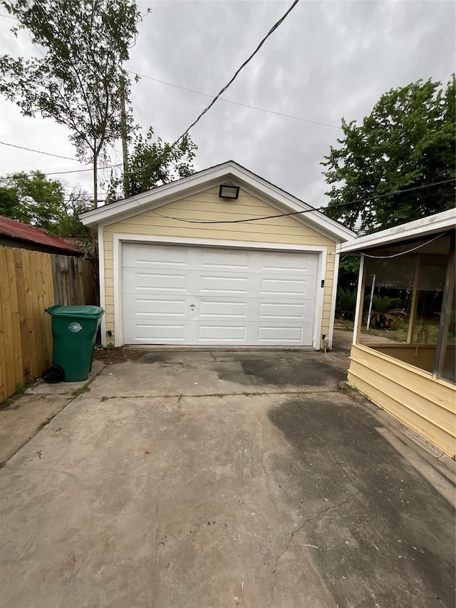 detached garage with fence and driveway