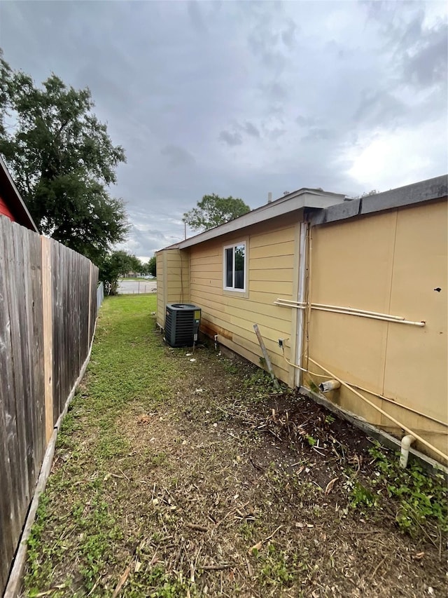 view of property exterior featuring cooling unit and fence