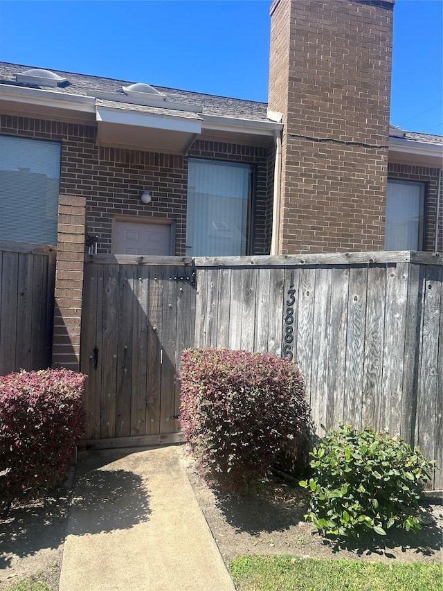 13886 Hollowgreen Dr Unit 808, Houston, TX 77082 - view of property exterior featuring fence, brick siding, and a chimney