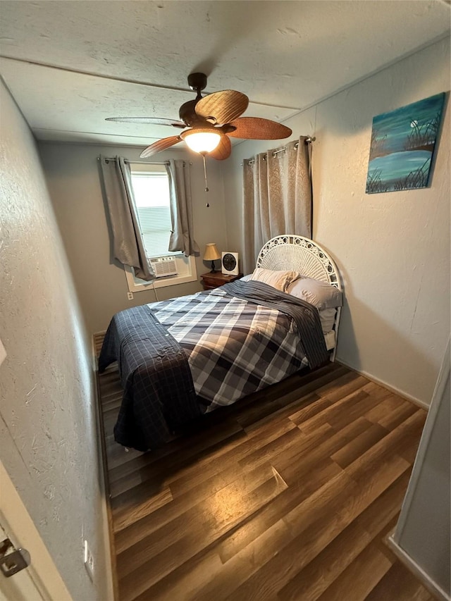 1428 Fm 2031st St S, Matagorda, TX 77414 - bedroom with wood finished floors, a textured wall, a ceiling fan, and cooling unit