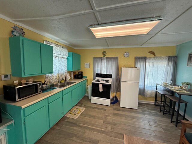 1428 Fm 2031st St S, Matagorda, TX 77414 - kitchen with range with electric stovetop, freestanding refrigerator, stainless steel microwave, a sink, and dark wood-type flooring