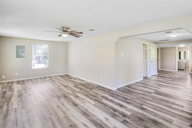 1011 N Arcola St, Angleton, TX 77515 - spare room featuring electric panel, light wood-style floors, baseboards, and a ceiling fan