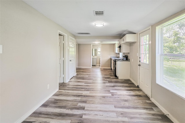 1011 N Arcola St, Angleton, TX 77515 - kitchen featuring white cabinetry, stove, baseboards, and wood finished floors