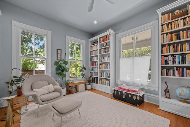1818 Decatur St, Houston, TX 77007 - living area featuring a ceiling fan, wood finished floors, and wall of books