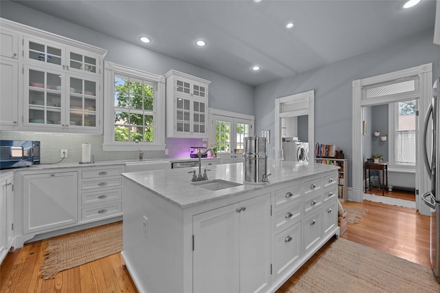 1818 Decatur St, Houston, TX 77007 - kitchen with light wood-type flooring, black microwave, washing machine and dryer, white cabinets, and recessed lighting