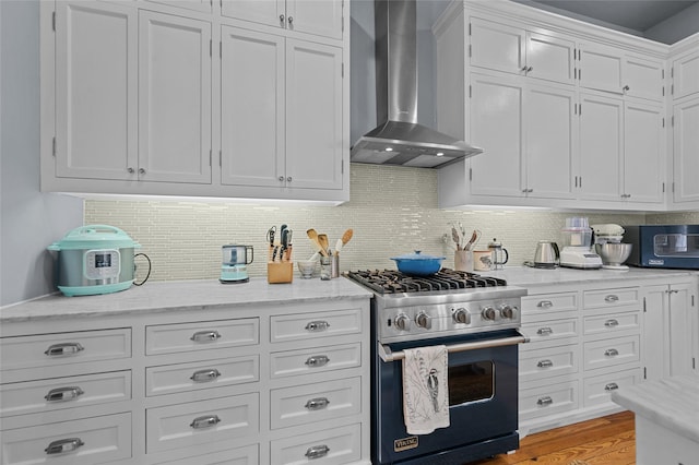 1818 Decatur St, Houston, TX 77007 - kitchen featuring stainless steel appliances, wall chimney range hood, white cabinetry, and decorative backsplash