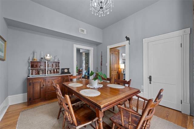 1818 Decatur St, Houston, TX 77007 - dining space with light wood-type flooring, a chandelier, and baseboards