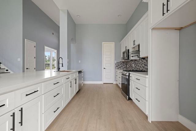 250 Hampton Glen Rd, Montgomery, TX 77356 - kitchen with appliances with stainless steel finishes, a sink, tasteful backsplash, light wood finished floors, and baseboards