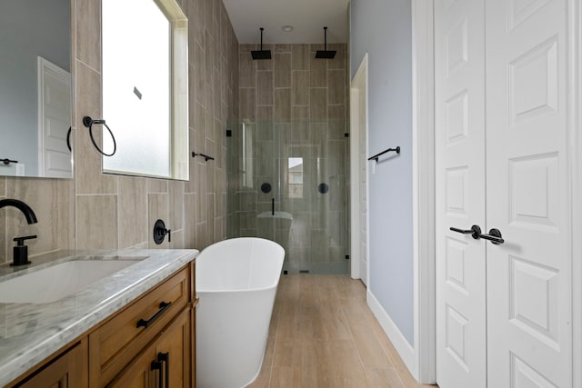250 Hampton Glen Rd, Montgomery, TX 77356 - full bath with a shower stall, vanity, a freestanding tub, wood finished floors, and tile walls