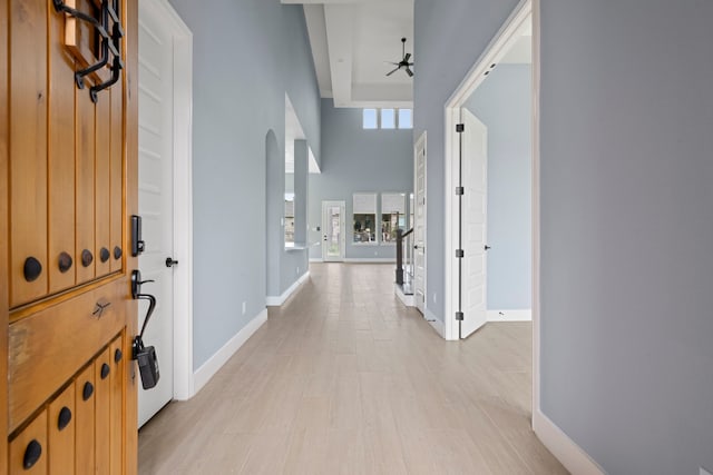 250 Hampton Glen Rd, Montgomery, TX 77356 - corridor with baseboards, a towering ceiling, light wood-style flooring, and arched walkways
