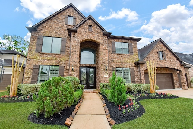 traditional-style home with french doors, brick siding, concrete driveway, and a front yard