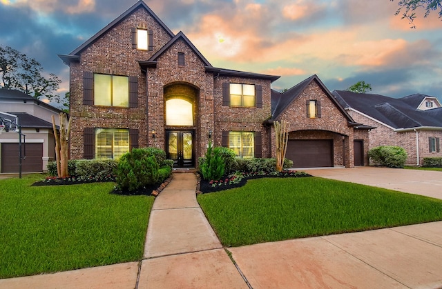 view of front of property with french doors, brick siding, concrete driveway, and a front lawn