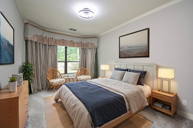 bedroom featuring ornamental molding and light carpet