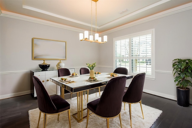 dining area featuring a tray ceiling, a chandelier, dark wood finished floors, and crown molding