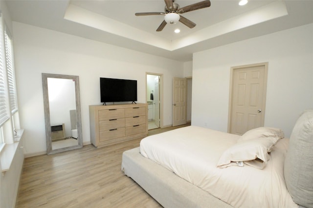 bedroom with a raised ceiling, light wood finished floors, recessed lighting, baseboards, and a ceiling fan