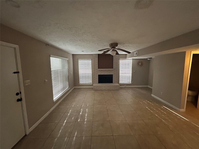 13507 White Cliff Dr, Houston, TX 77065 - unfurnished living room with a ceiling fan, plenty of natural light, tile patterned floors, a fireplace, and a textured ceiling