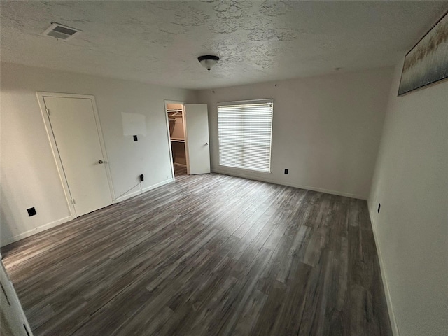 13507 White Cliff Dr, Houston, TX 77065 - unfurnished bedroom featuring wood finished floors, baseboards, a textured ceiling, a walk in closet, and a closet