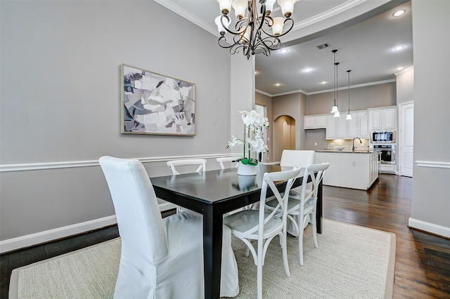 6315 Asbury Brook Ct, Katy, TX 77493 - dining room with crown molding, a chandelier, dark wood-style floors, arched walkways, and baseboards
