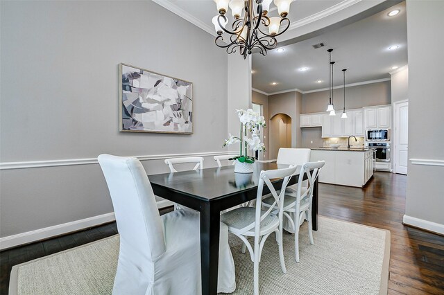 6315 Asbury Brook Ct, Katy, TX 77493 - dining space with ornamental molding, a chandelier, dark wood-style flooring, recessed lighting, and arched walkways