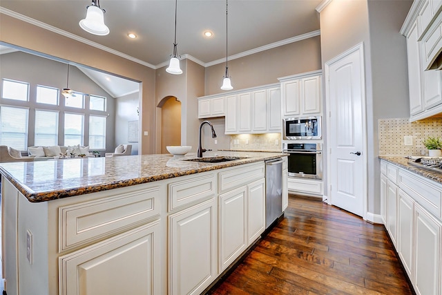 6315 Asbury Brook Ct, Katy, TX 77493 - kitchen featuring a sink, stainless steel appliances, arched walkways, dark wood finished floors, and backsplash