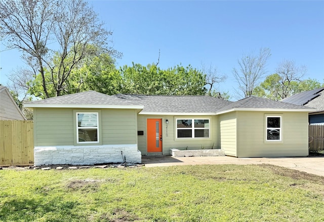 single story home featuring a shingled roof, stone siding, and a patio area