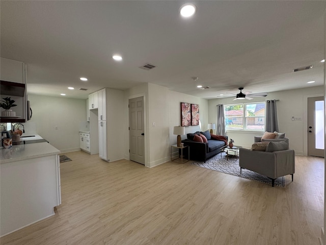 living area featuring light wood-style floors, recessed lighting, ceiling fan, and baseboards