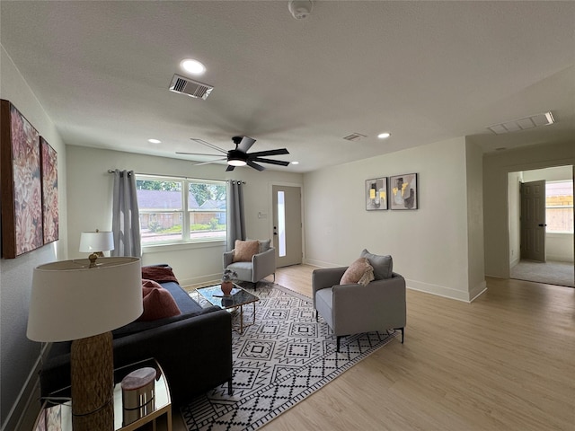 living room with light wood-style flooring, ceiling fan, baseboards, and recessed lighting