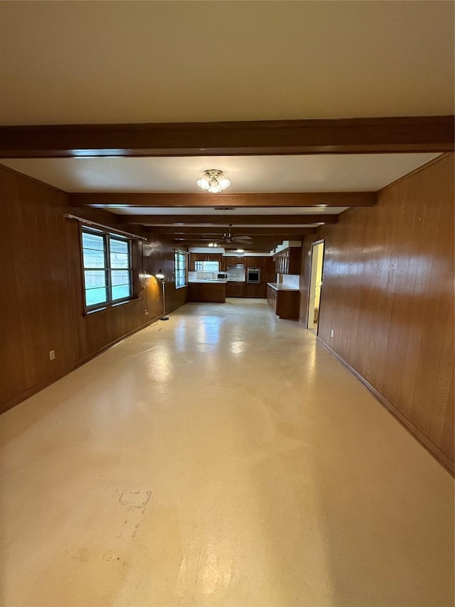 corridor featuring beamed ceiling and wooden walls
