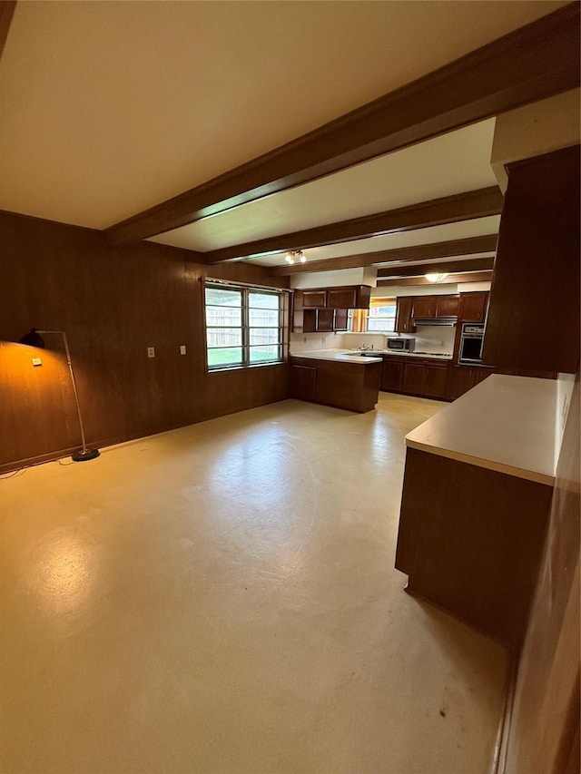 unfurnished living room with beam ceiling and finished concrete flooring
