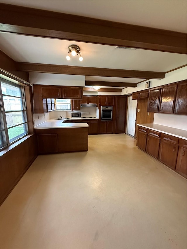 kitchen featuring wall oven, a peninsula, beam ceiling, light countertops, and dark brown cabinets
