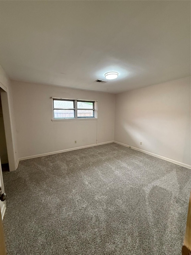 unfurnished room featuring carpet floors and baseboards