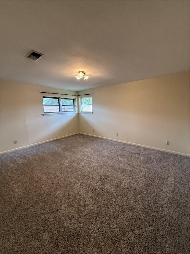 unfurnished room with carpet flooring and baseboards