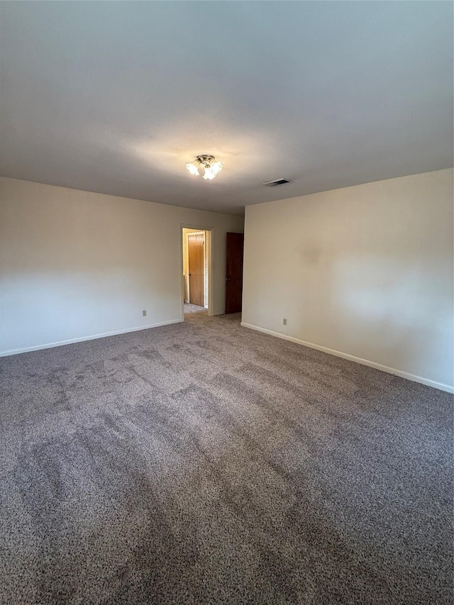 carpeted empty room featuring baseboards