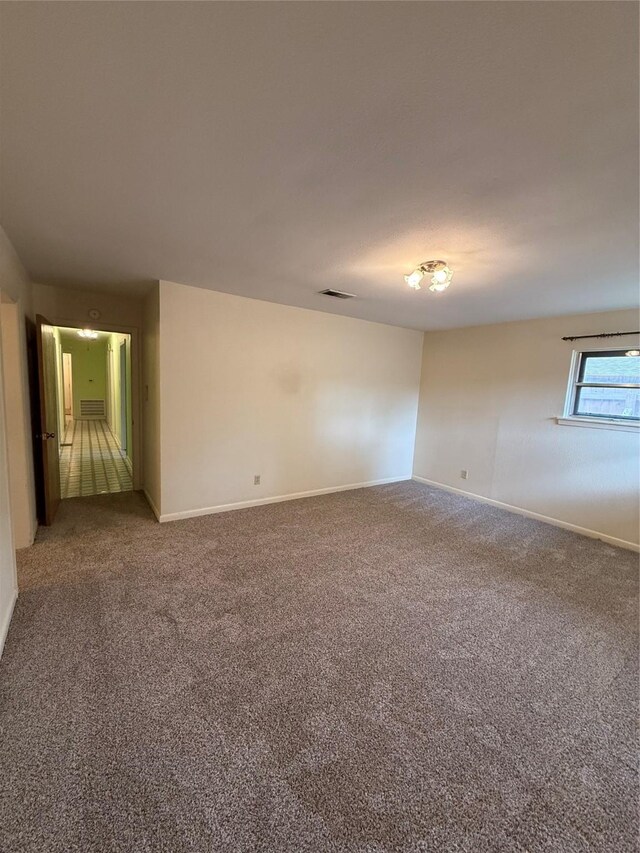 carpeted empty room featuring baseboards