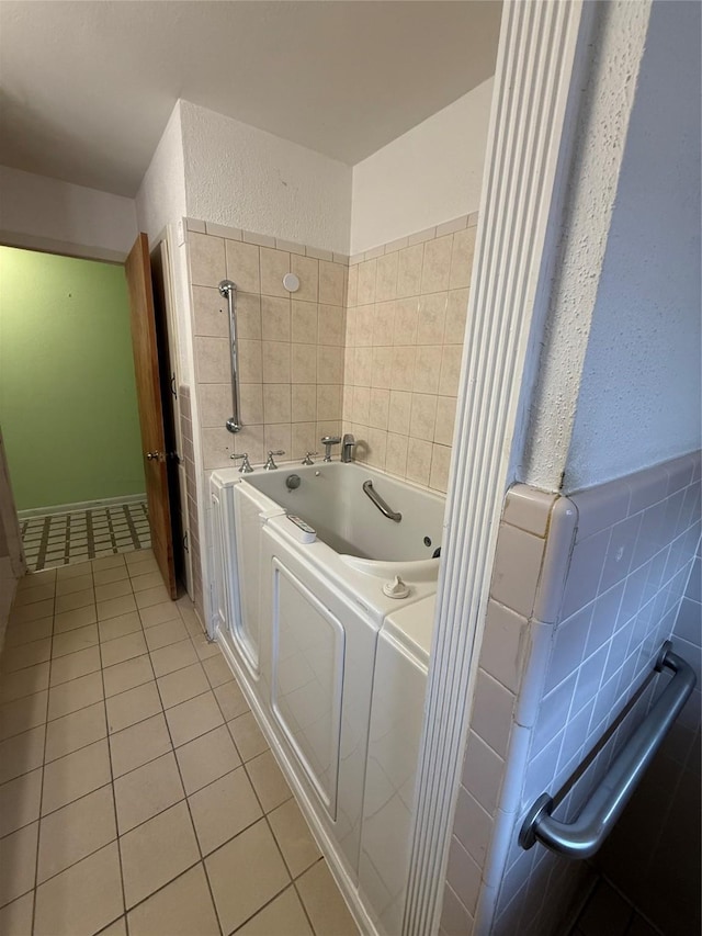 full bath featuring tile patterned flooring, a textured wall, and a garden tub