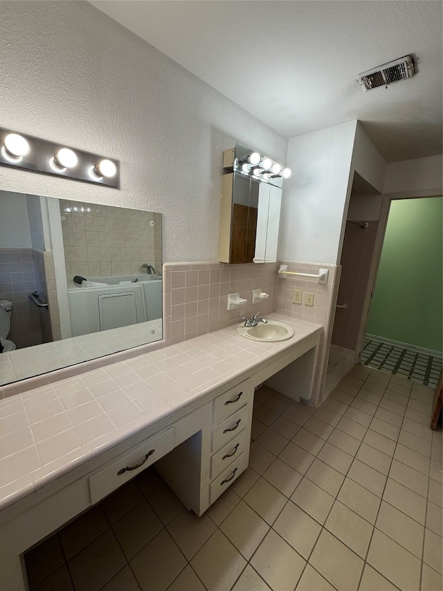 bathroom with tile patterned flooring, backsplash, and vanity