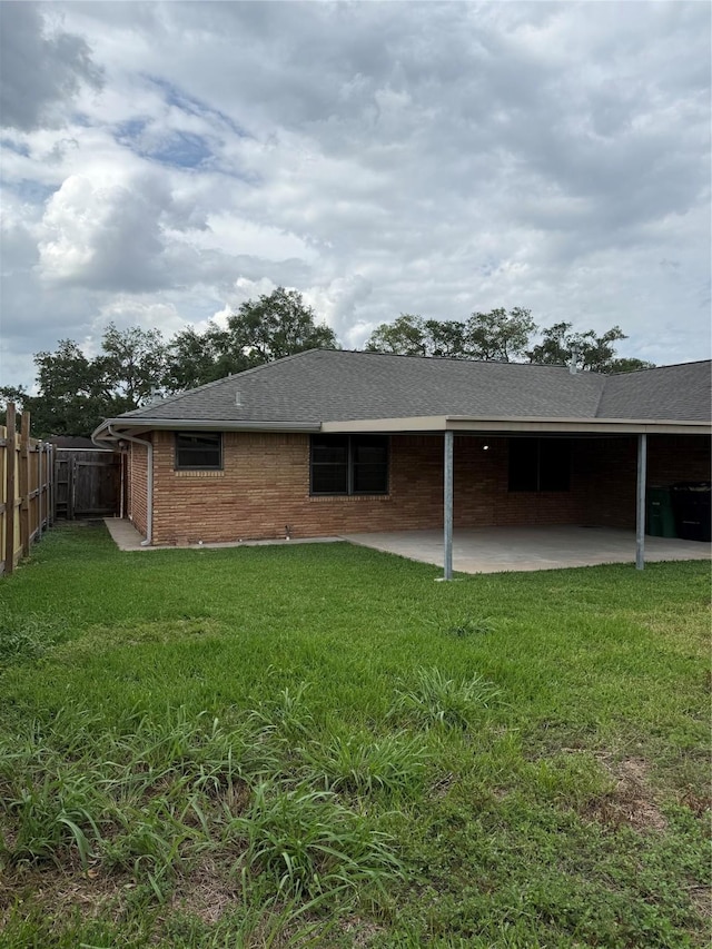 back of house featuring a patio area, brick siding, and roof with shingles