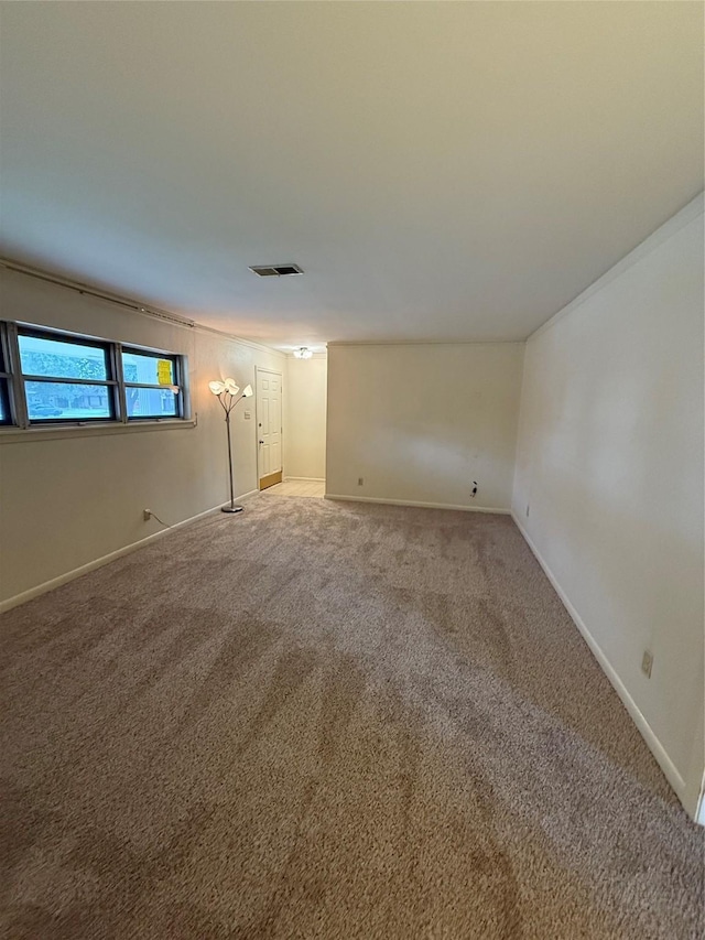 unfurnished room featuring light carpet and baseboards