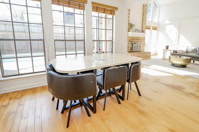 11810 Braesridge Dr, Houston, TX 77071 - dining area featuring a fireplace, light wood-style floors, and baseboards
