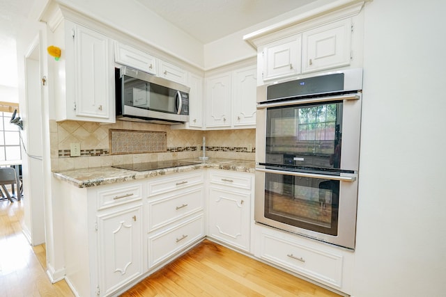 11810 Braesridge Dr, Houston, TX 77071 - kitchen featuring appliances with stainless steel finishes, light wood-type flooring, decorative backsplash, light stone countertops, and white cabinetry