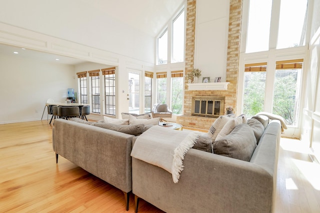 11810 Braesridge Dr, Houston, TX 77071 - living area featuring wood finished floors, a towering ceiling, a brick fireplace, and baseboards